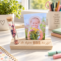 Houten fotoplankje met gepersonaliseerde tekst en glazen buisje met roze en paarse droogbloemen.