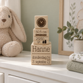 Set houten geboortekubussen met gepersonaliseerde tekst en gravures van klok en meetinstrument in natuurlijke kleur.