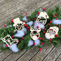 Vijf grappige houten kerstballen in verschillende vormen met uitgesneden namen zoals Maarten, Lieze, Jonas, Thomas en Marie.