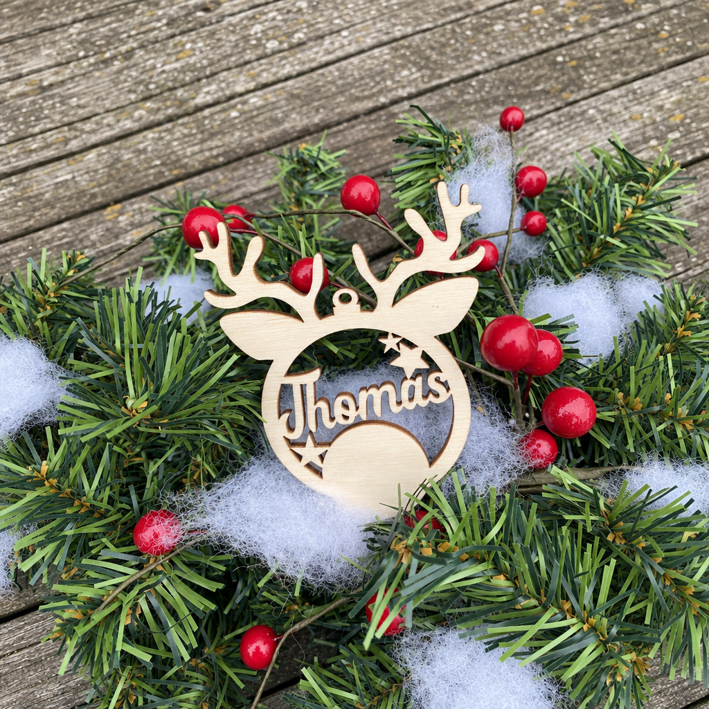Houten kerstbal in ronde vorm met rendiergewei en de naam Thomas uitgesneden in natuurlijke houtkleur.