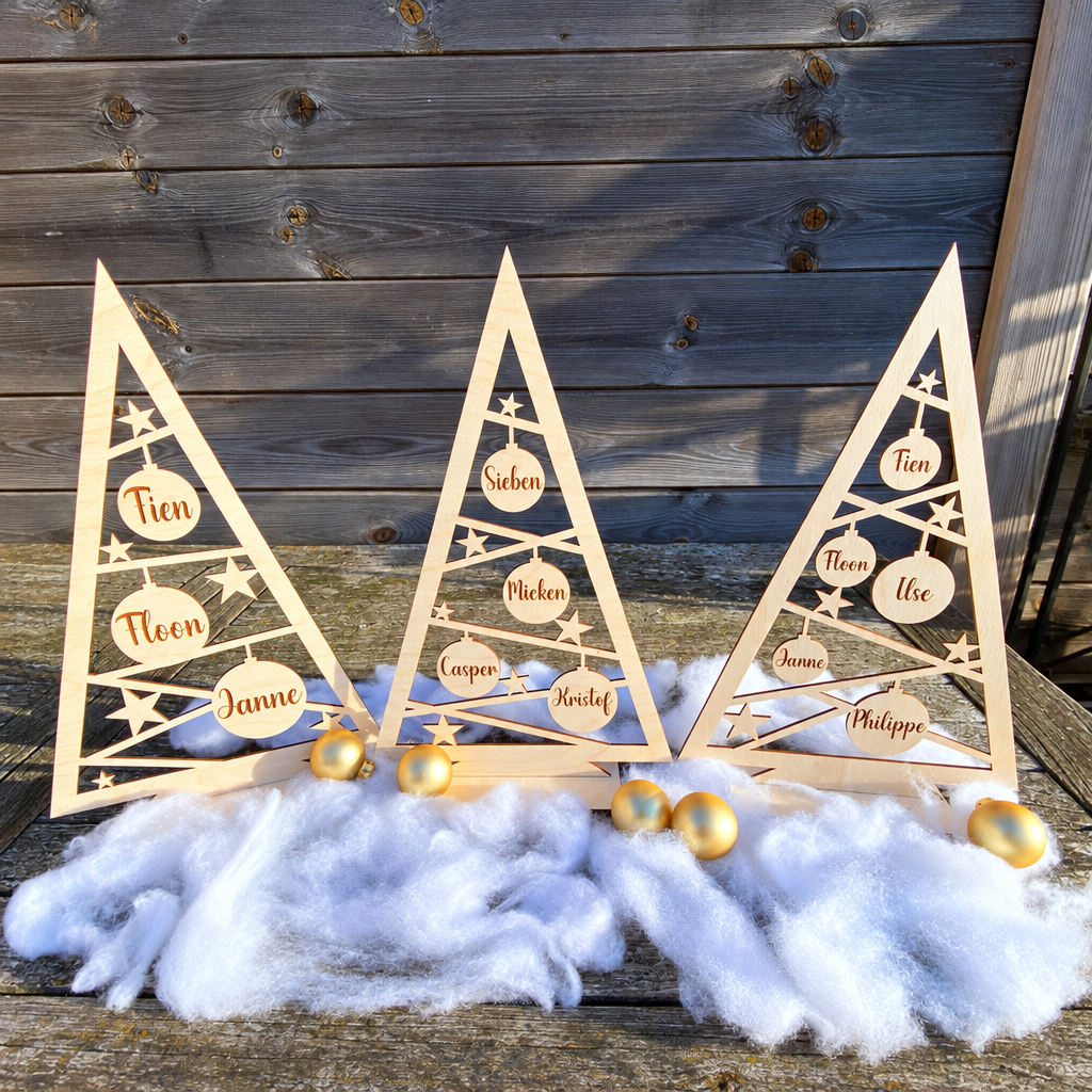 Drie houten kerstboompjes met gesneden sterren en kerstballen met gepersonaliseerde namen in natuurlijke houtkleur.