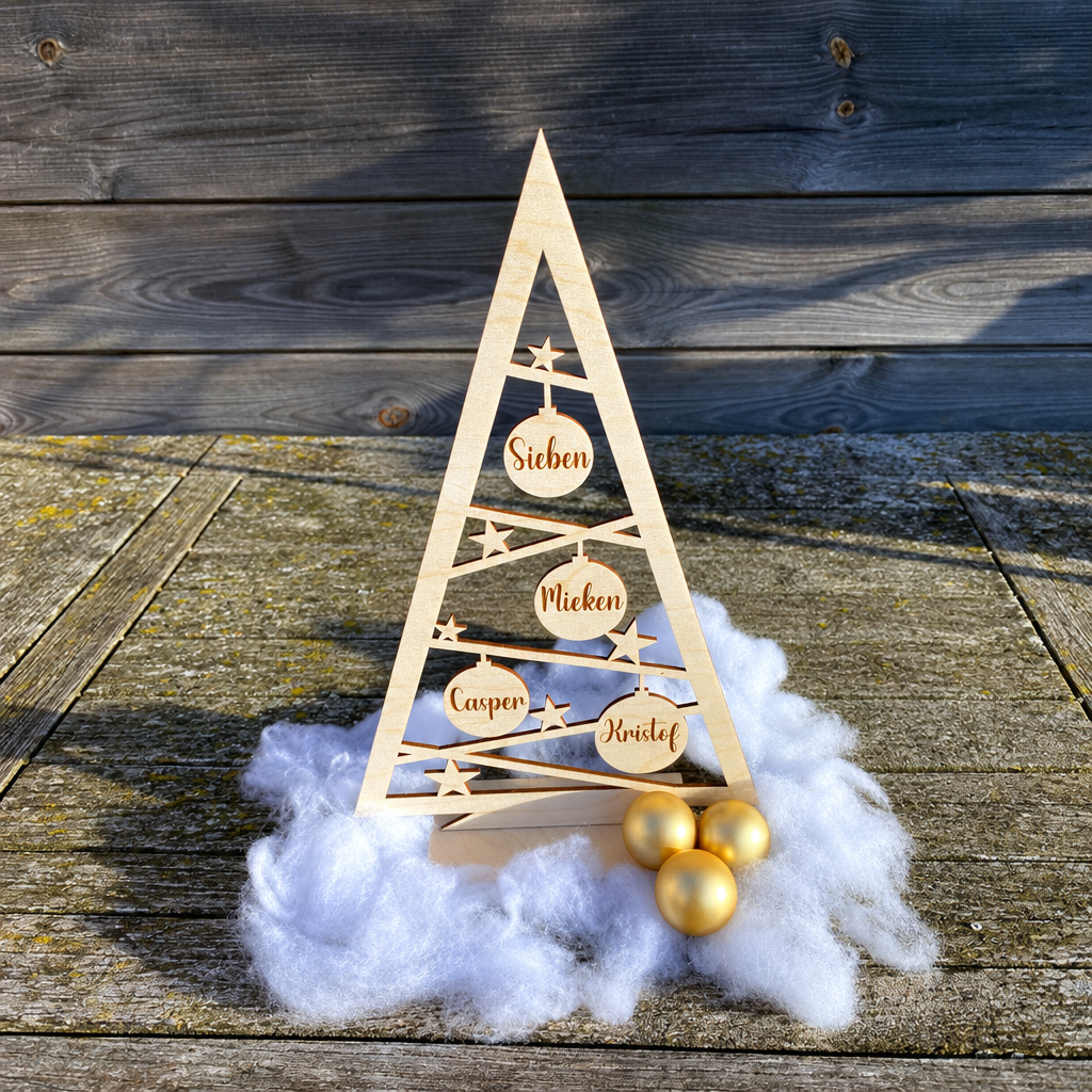 Houten kerstboom in driehoekige vorm met uitgesneden sterren en ruiten, voorzien van vijf ronde labels met de namen Sieben, Mieken, Casper en Kristof.