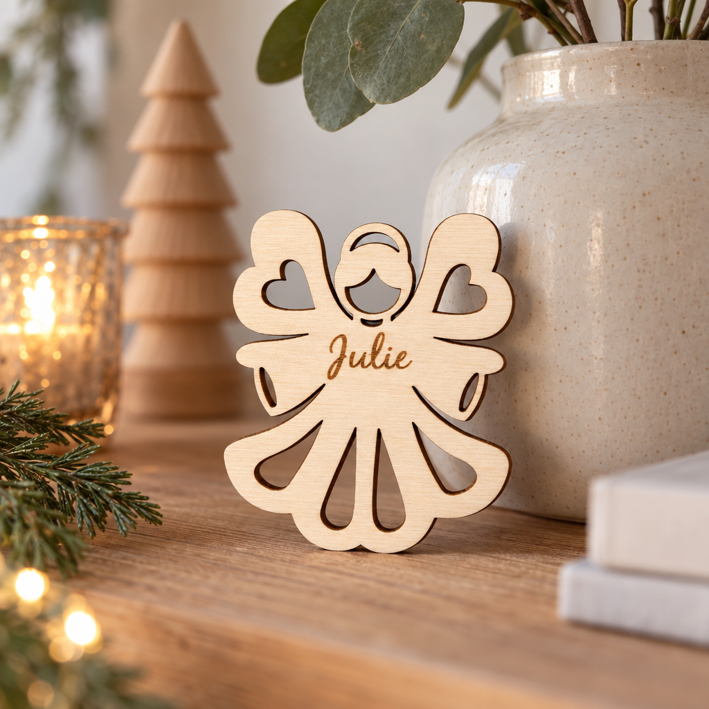 Houten engelvormige kerstdecoratie met de naam Julie gegraveerd, licht beige van kleur met uitgesneden details.
