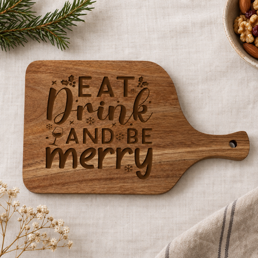 Kleine houten hapjesplank met handvat, rechthoekig met afgeronde hoeken en gegraveerde tekst "EAT Drink AND BE merry" met kerstmotieven.