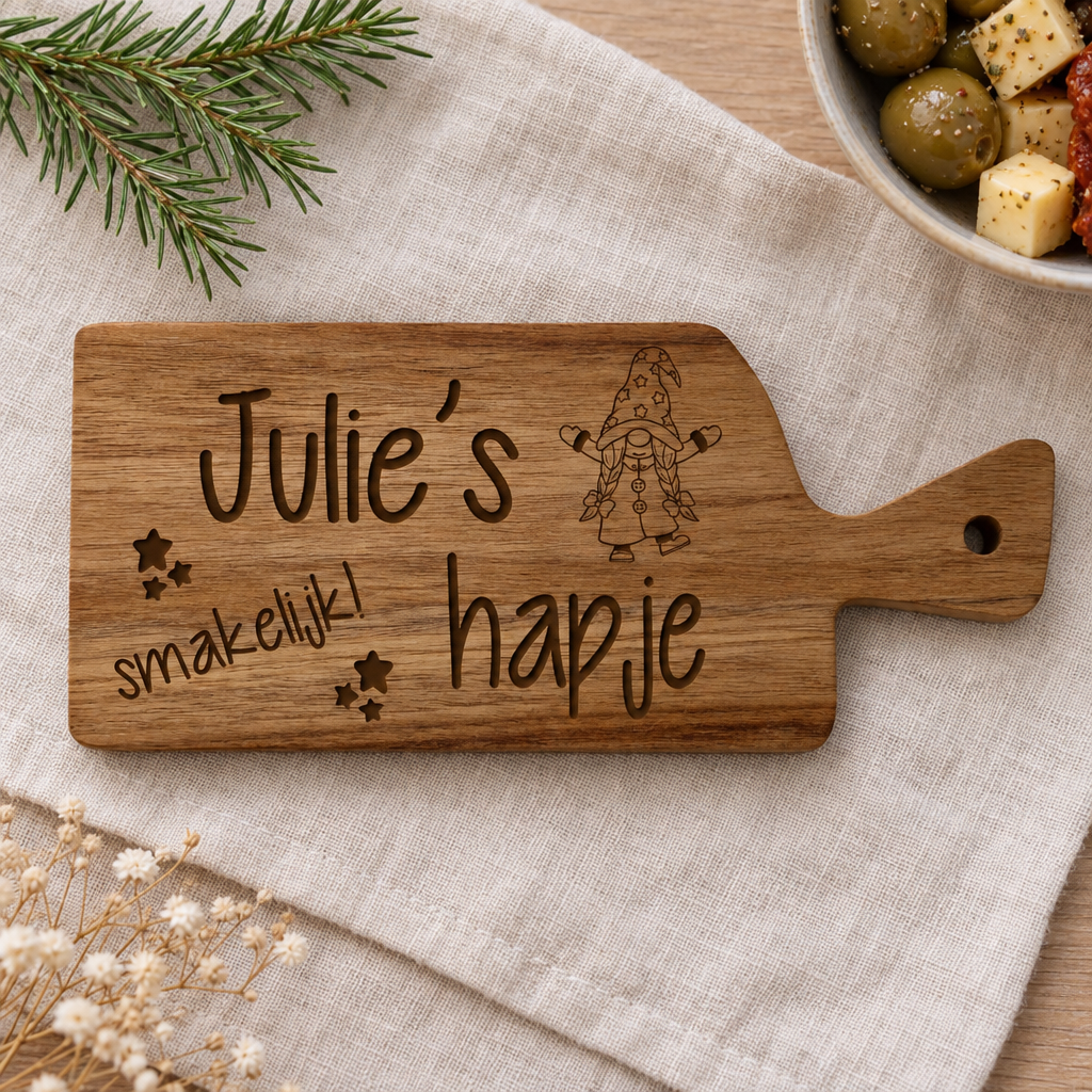 Kleine rechthoekige houten hapjesplank met handvat, gegraveerd met tekst "Julie’s hapje smakelijk!" en een kaboutermotief.