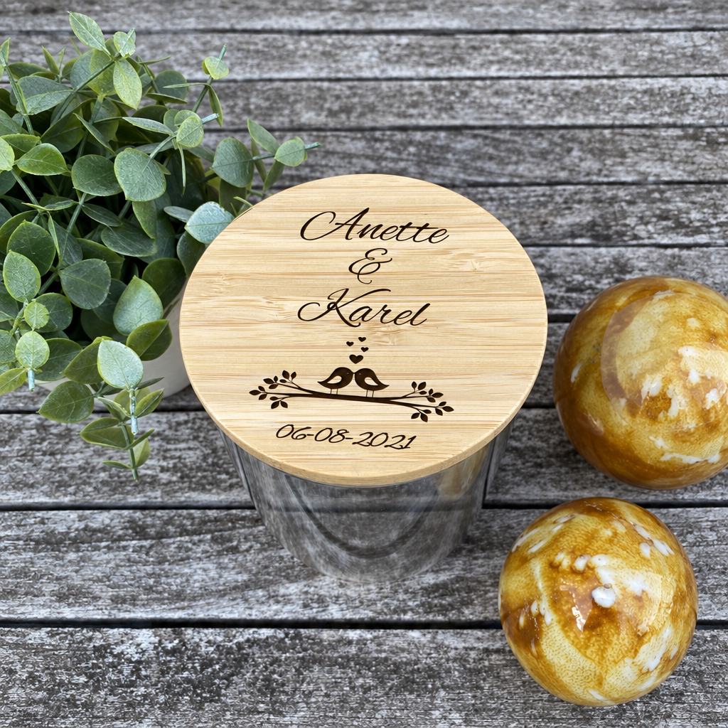 Ronde glazen snoeppot met een houten deksel met een gegraveerde gepersonaliseerde tekst en een design van twee vogels.